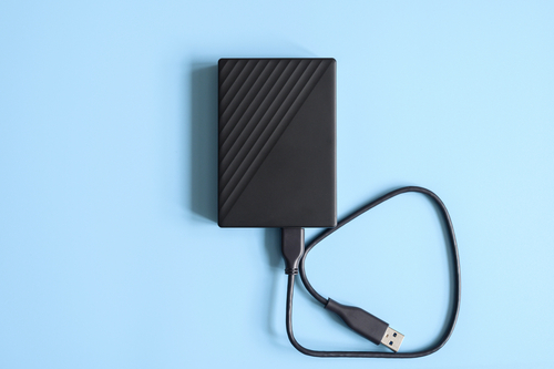 External,Hard,Drive,Black,Color,With,Connection,Cable,On,Blue